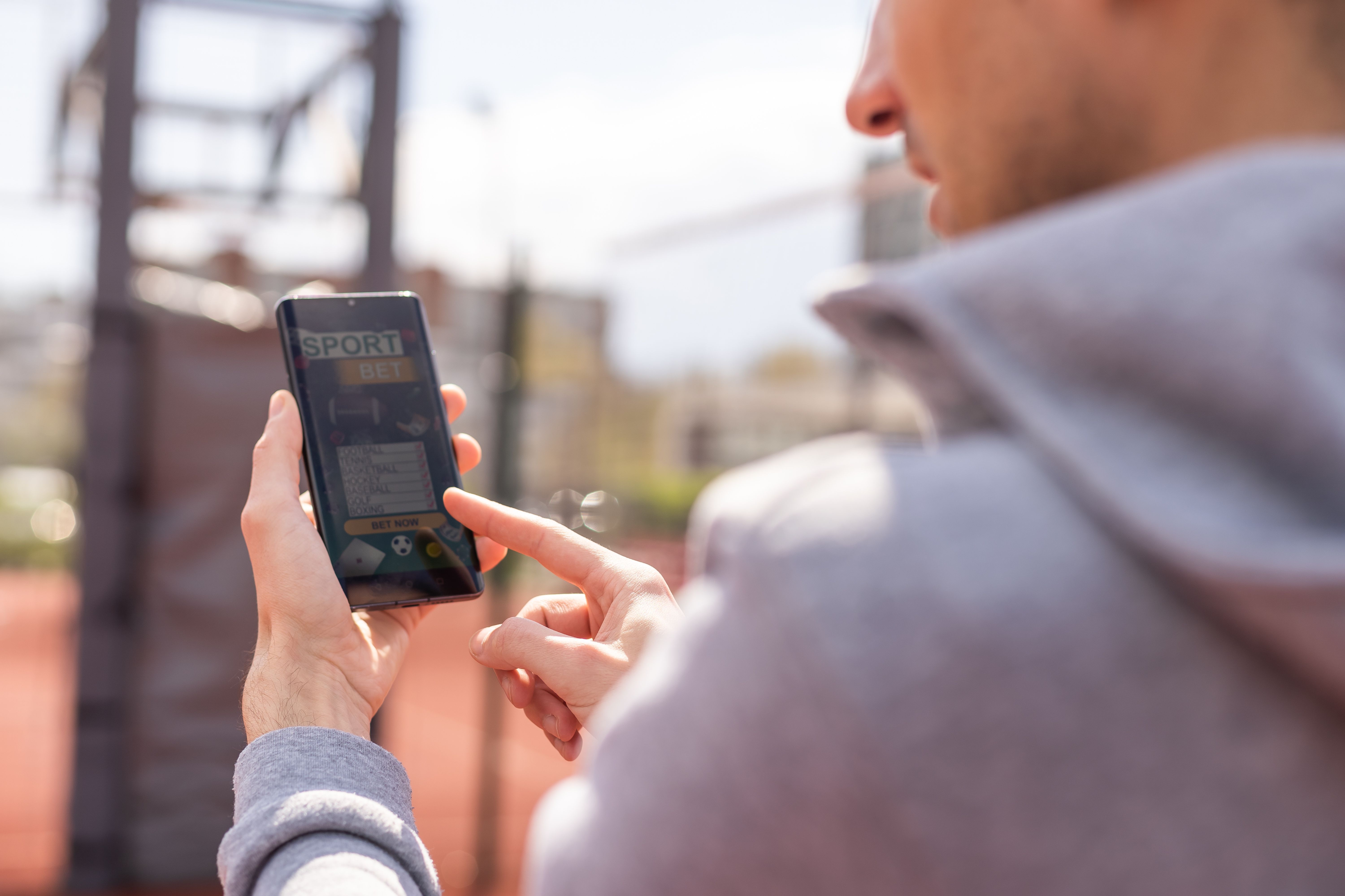 Man using online sports betting services on phone