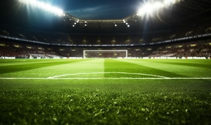 Football field at night, illuminated by stadium lights. Green grass macro in sports arena