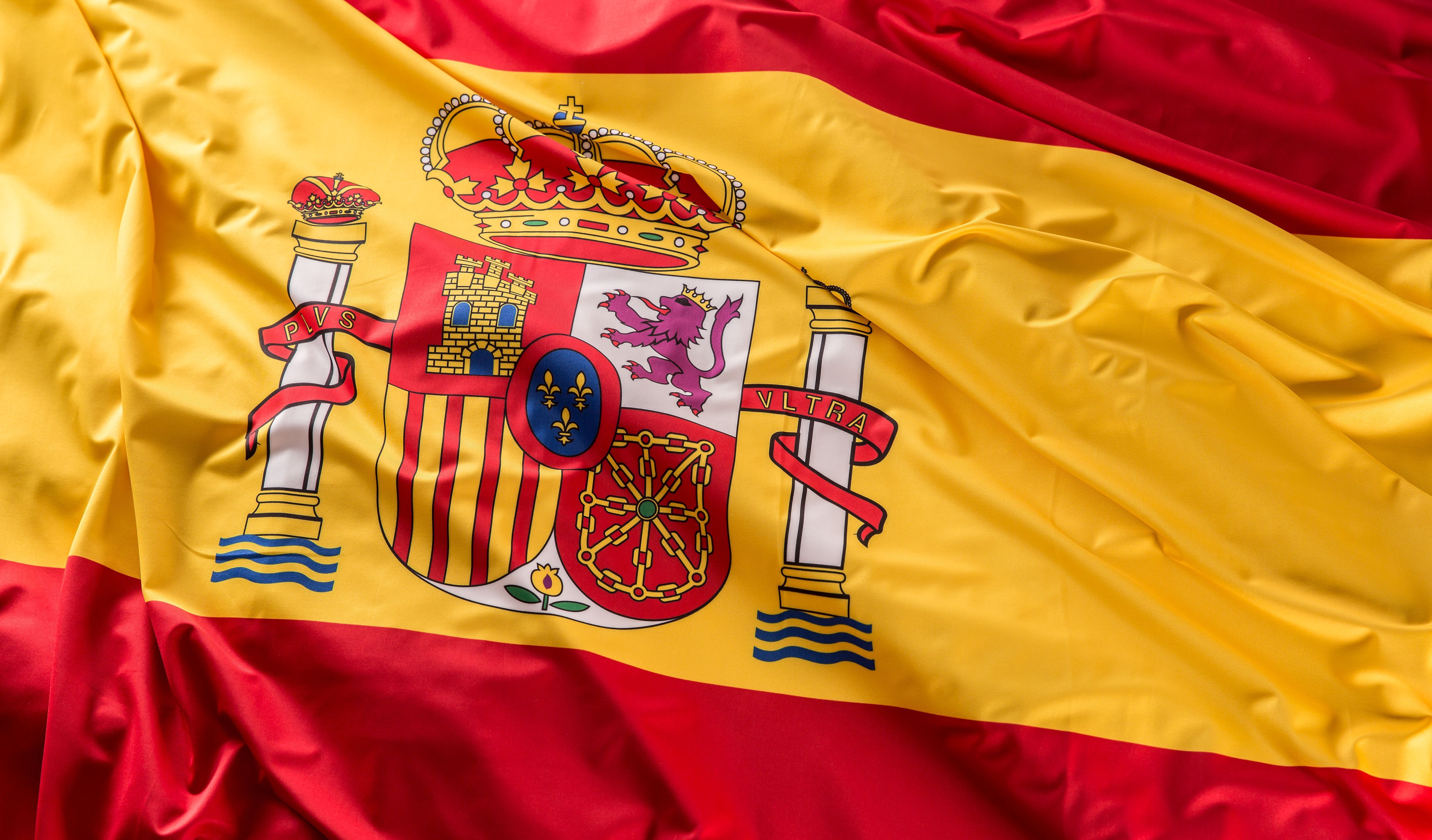 Spain flag of silk. Spanish national colours with emblem.