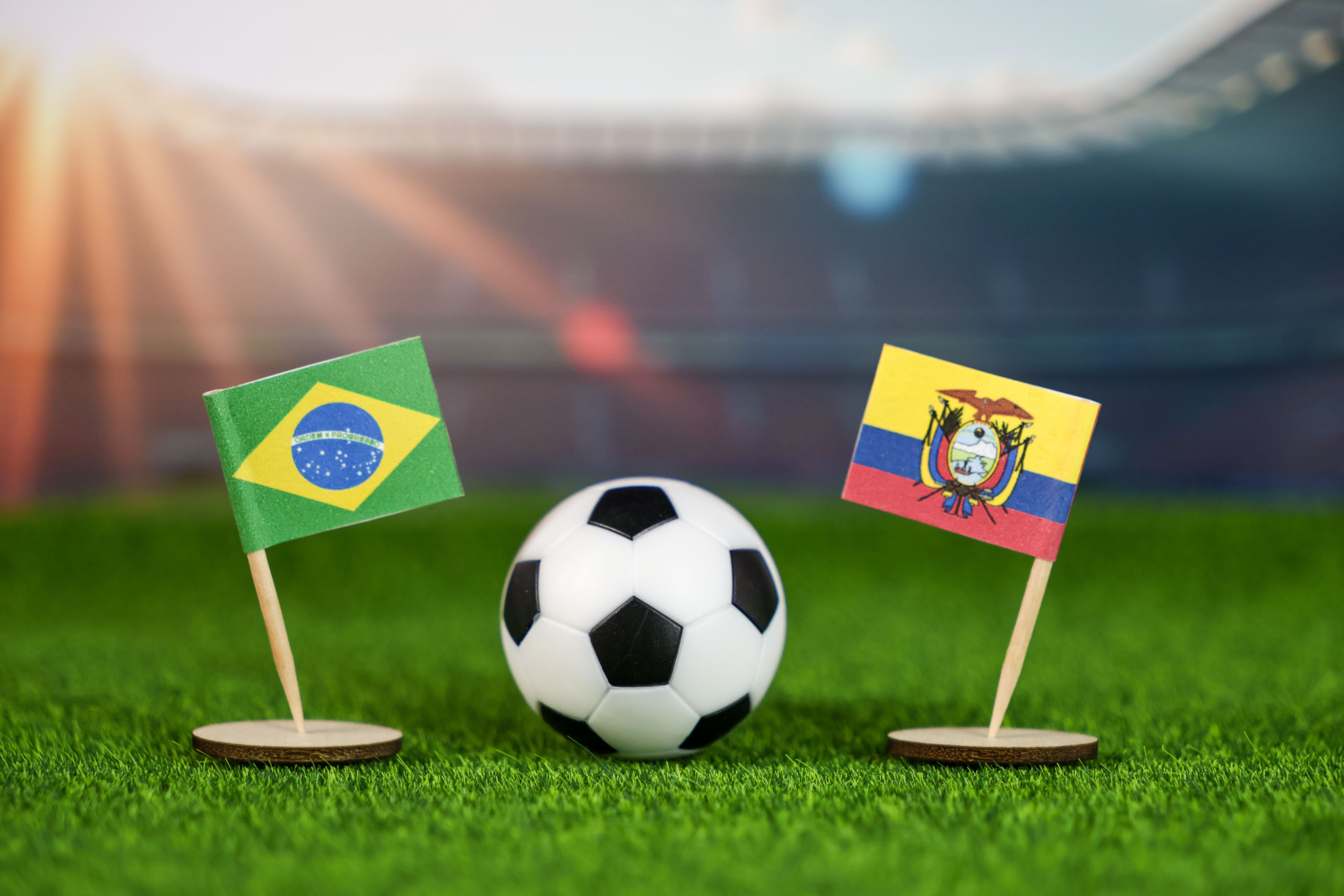 brazil vs ecuador football rivalry with national flags, soccer ball on green field, and stadium background, highlighting south american sports passion