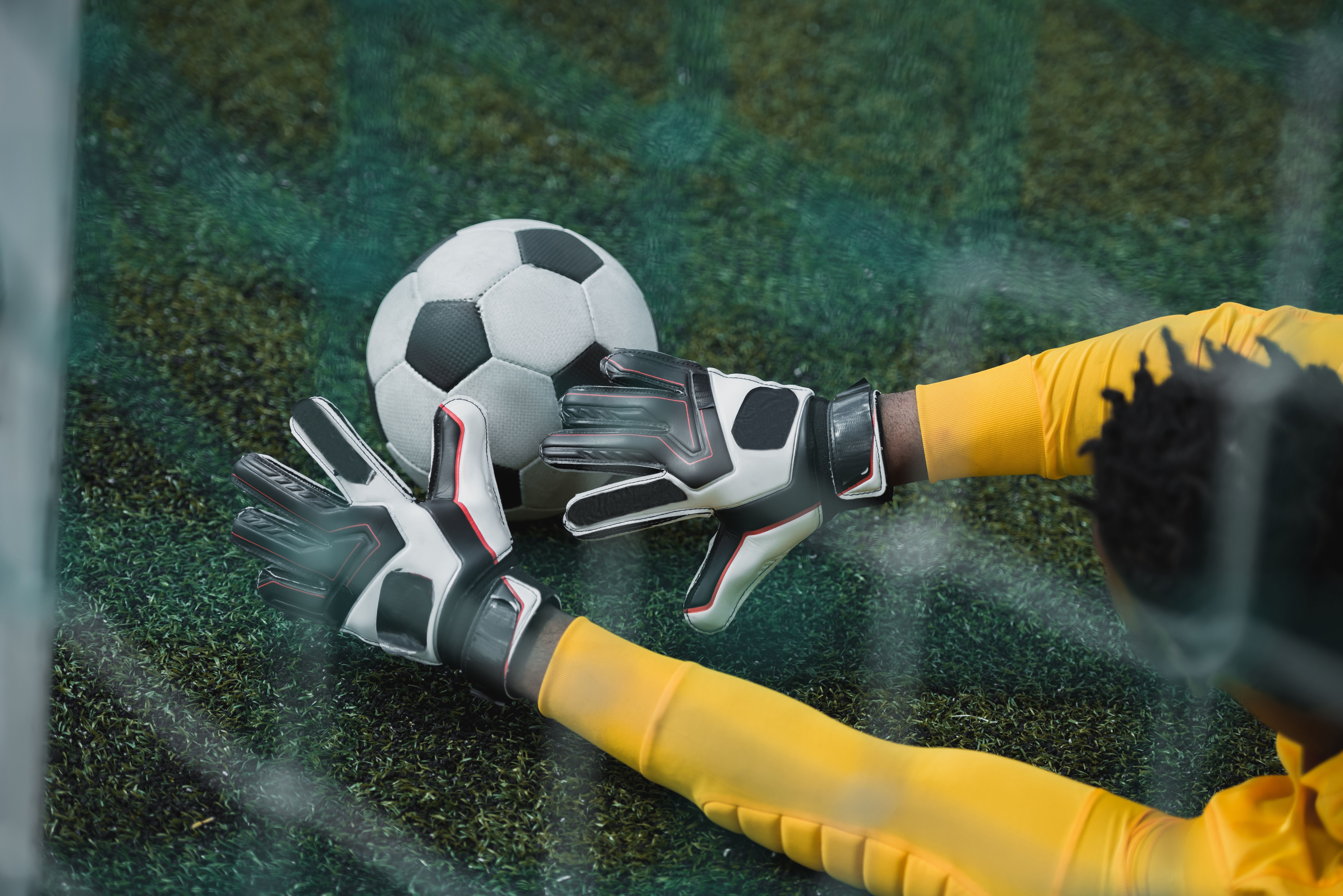 african american goalkeeper catching soccer ball during game