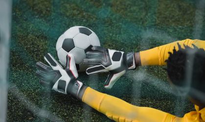 african american goalkeeper catching soccer ball during game