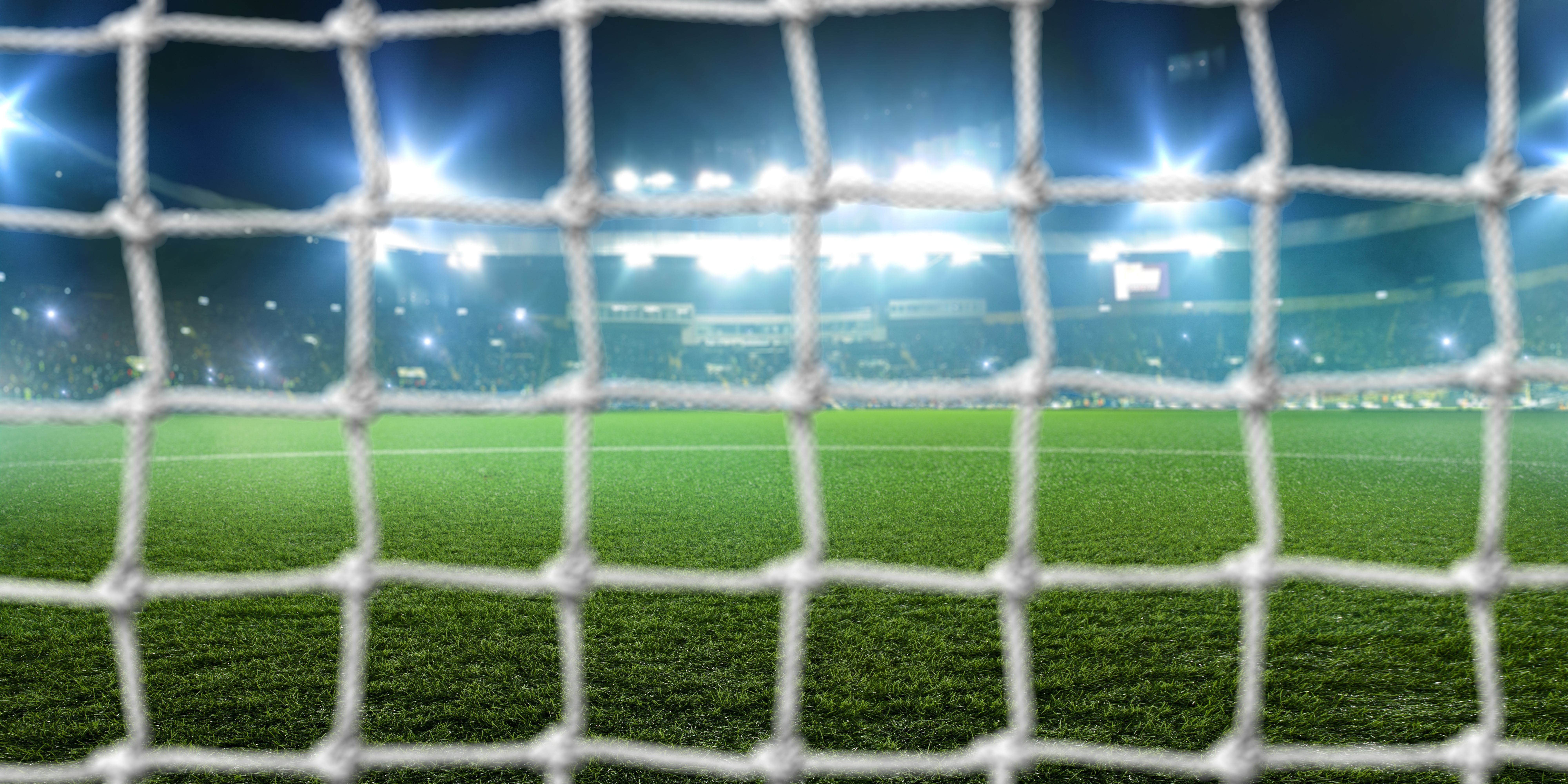 Football goal on stadium, shiny lights and tribune