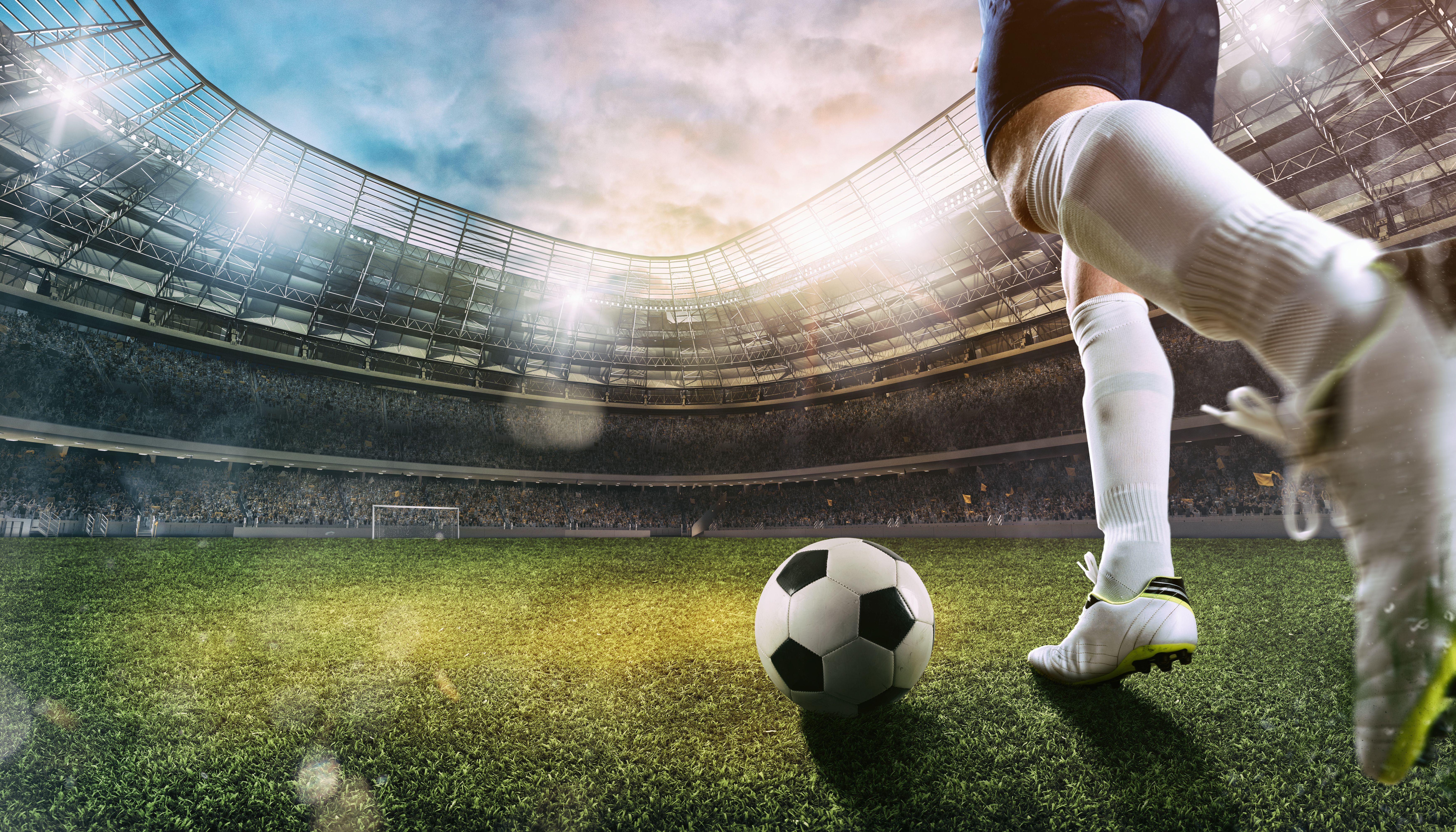 Football scene at the stadium with close up of a soccer shoe kicking the ball