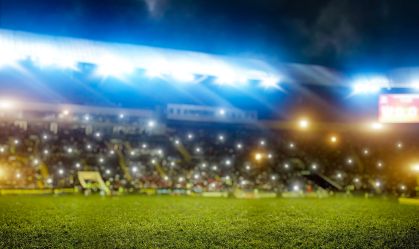 Football stadium, tribunes with fans, shiny lights