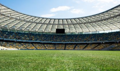grassy football pitch at stadium at sunny day with blue sky
