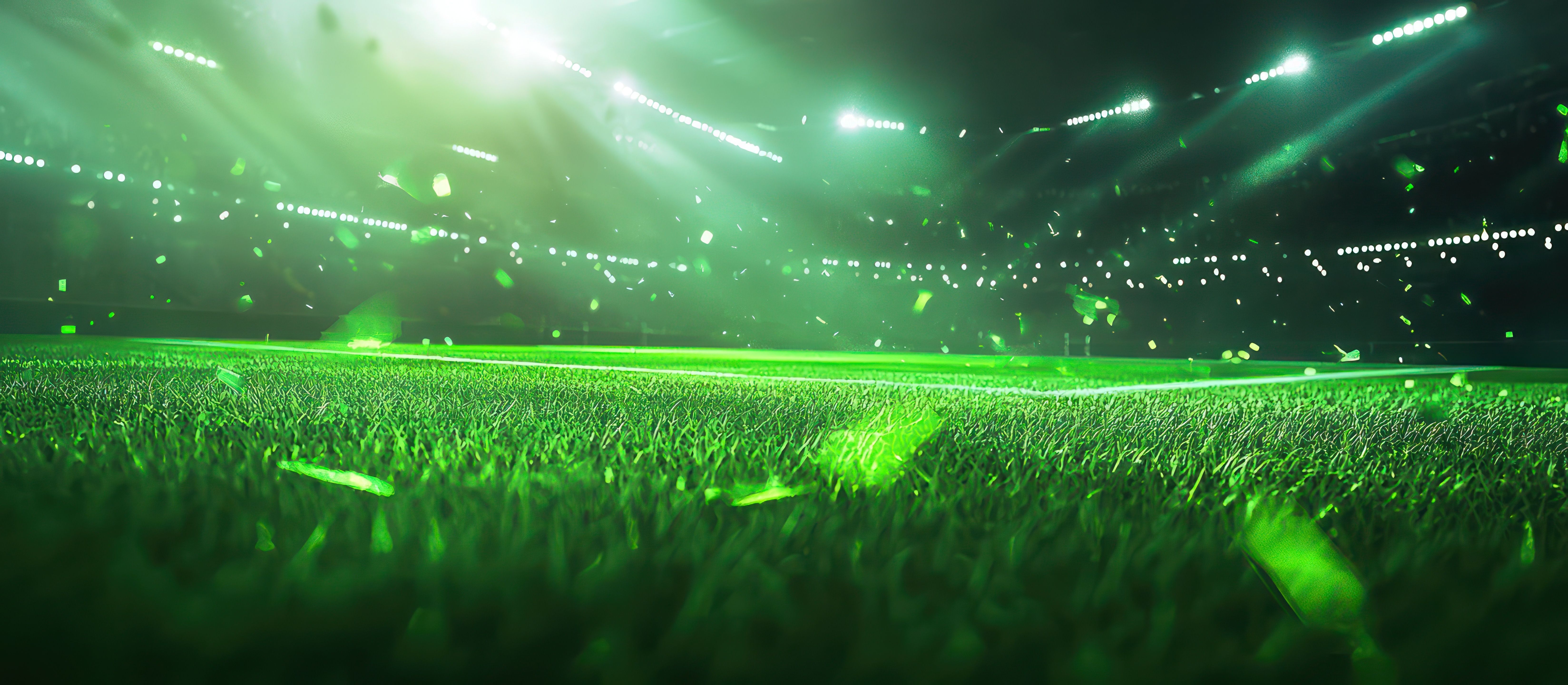 Lit soccer stadium with an empty green field.
