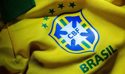 camisa oficial  da Seleção do Brasil de Futebol, a famosa camisa canarinho ao lado um crucifixo para proteção e para atrair boa sorte.