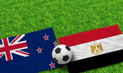 New Zealand and Egypt flags with soccer ball on green grass