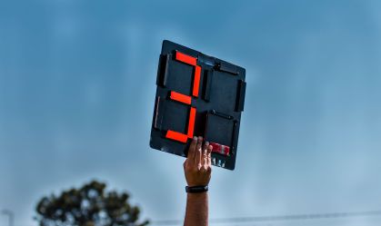 Assistant Football referee shows extra time
